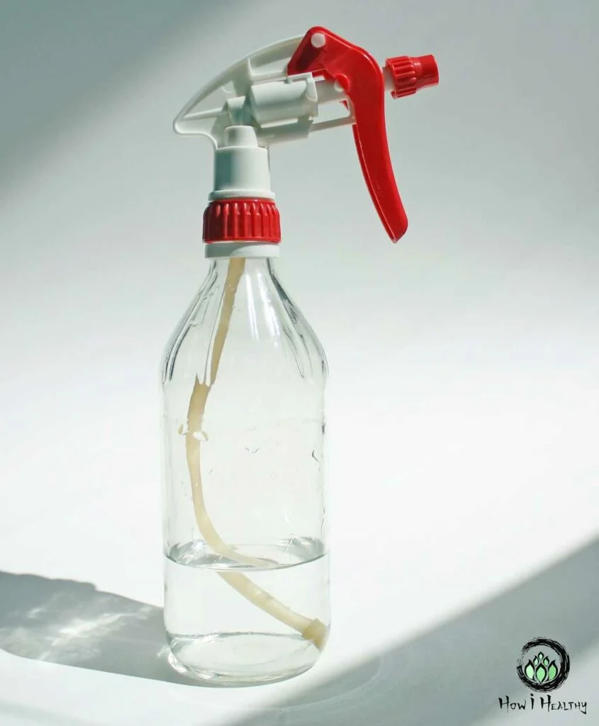 Glass Spray Bottle Simple, Water-Free, & Zero Waste Cleaning Guide DIY glass spray bottle with red nozzle filled with cleaning solution.
